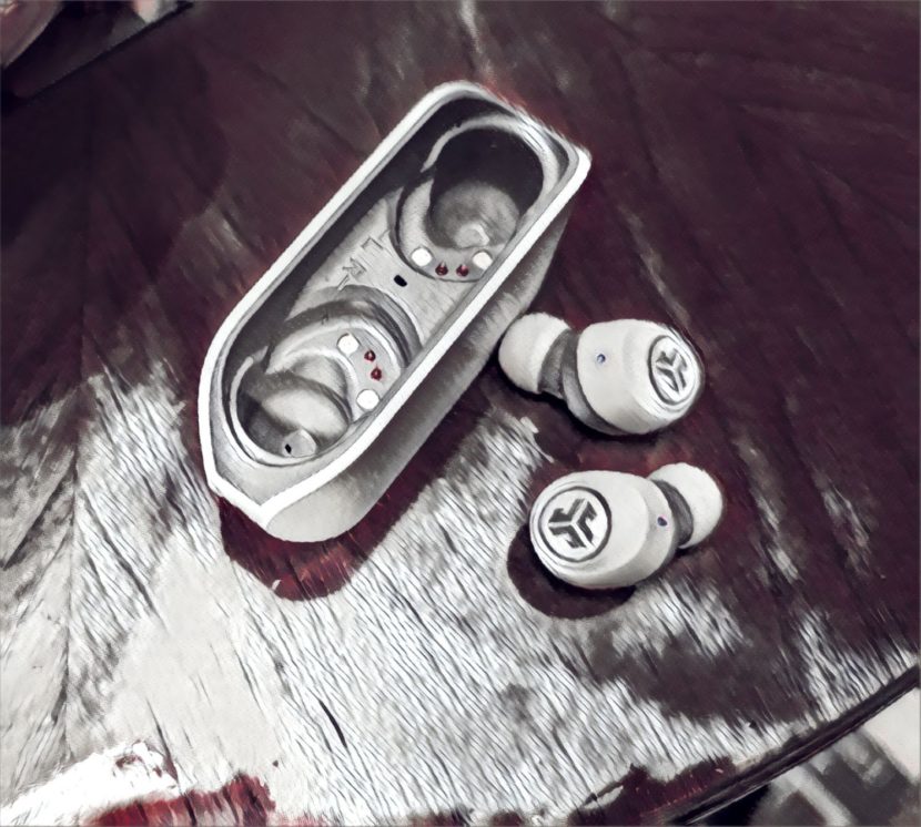 a pair of earbuds out of their case on a table